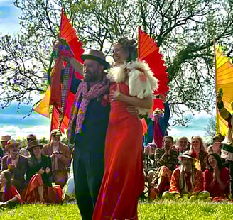 large outdoor spring handfasting ceremony of royal orange and navy blues, yellows and golds.
