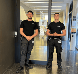Zwei Sicherheitskräfte in "SECURITY"- Shirts