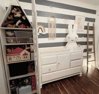 Organized kids’ room with toy shelves, dresser, and playful minimalist decor.