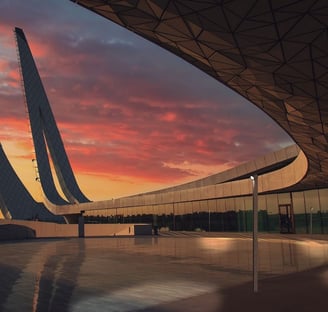 Fachada arquitectónica con sistema de lamas y diseño lumínico exterior al atardecer