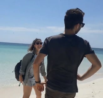 a man and woman standing on a beach