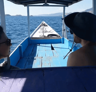 two people are sitting on a boat in the ocean