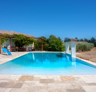 Swimming pool with beach chairs, wide view and waterfall cascade built-in at Domaine Des Lucques