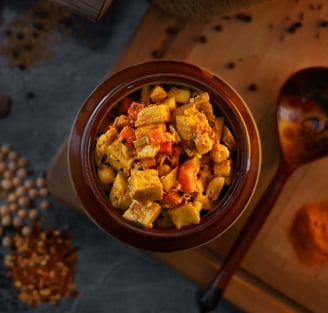 a bowl of food with a wooden spoon and a wooden spoon