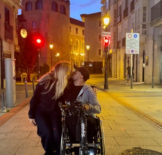 a man and woman kissing on a city street