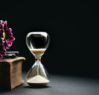 a hourglass, book and a flower