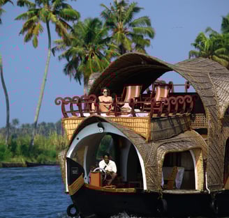 Luxury houseboat cruising through Kerala’s serene backwaters near Alleppey.