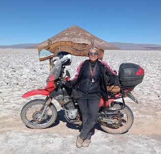 a man sitting on a motorcycle in the desert cono de arita puna atacama salar