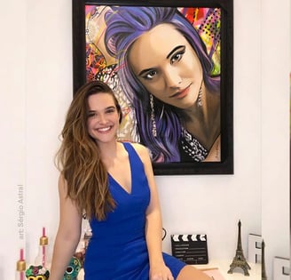 Um cliente sorrindo enquanto observa sua nova pintura Pop-Art personalizada em casa.