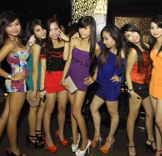 a group of young women standing in front of a bar