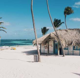 Beach hut on white sand with palm trees and turquoise water in Punta Cana, Dominican Republic