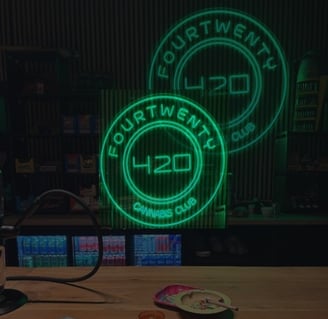Interior de Fourtwenty 420 Cannabis Club con letreros LED verdes