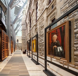 a hallway with a glass roof decorated with portrait art displays