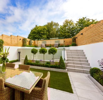 a patio with a table and chairs and stairs