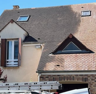 a truck with a ladder and a ladder in front of a house