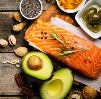 A wooden table featuring salmon, avocado, highlighting nutrient-dense foods for metabolic.