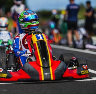 Pilote de kart numéro 1 attendant le départ d'une course sur la ligne de départ.