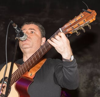 a man with a guitar and microphone in front of a microphone