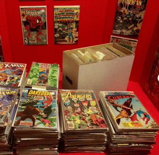 a table with a lot of comics books and comics
