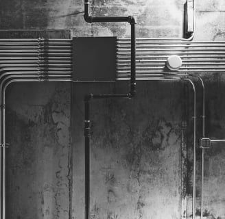 Neatly organized exposed electrical conduits on an industrial concrete wall for MEP planning.