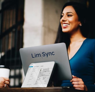 a woman sitting at a table with a laptop and a coffee cup