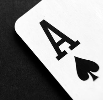 The corner of a playing card, the ace of spades, against a black fabric background.