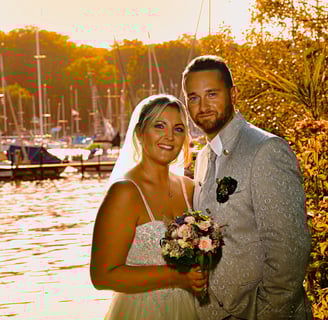 a bride and groom standing in front of a lake