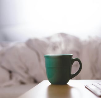 a cup of coffee and a keyboard on a table