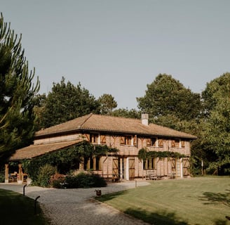 a house with a large wooden house domain de Petiosse
