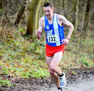 a man running on a trail in the woods