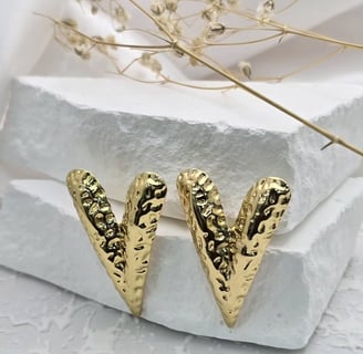 a pair of gold toned earrings with a gold leaf design