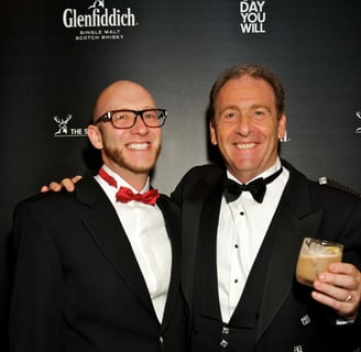 two men in kilts and happy and enjoying an event