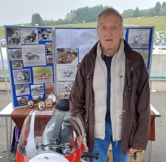 Ronnie standing proudly beside a motorbike, reflecting his passion for racing and the inspiration be