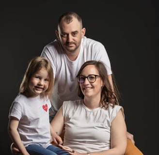 Couple avec un enfant, fauteuil jaune et fond noir