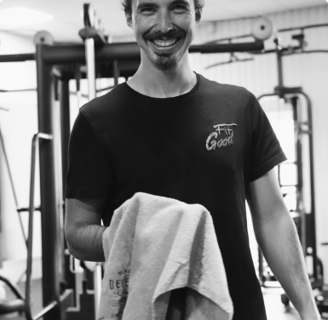 a man in a black shirt is holding a towel in the gym