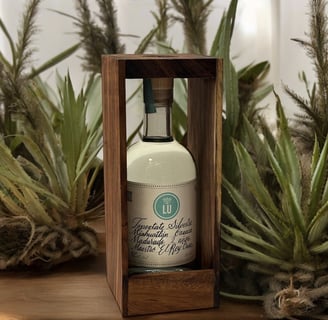 Botella de lu mezcal tepextate silvestre con fondo blanco y plantas de mezcal, botella caja madera
