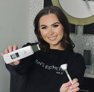 A beautiful woman smiling while holding a skin care tool