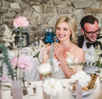 a man and woman sitting at a table with flowers