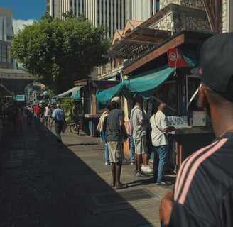 Street photography scene showing daily life outside food stalls at the Central Market in Port Louis, Mauritius