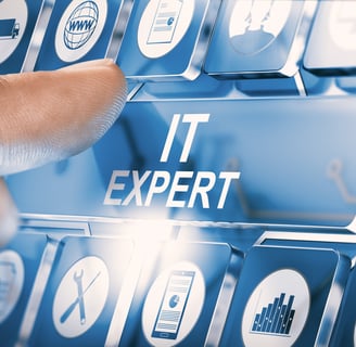 Finger pressing "IT expert" key on a keyboard with icons representing IT services and infrastructure