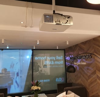 Epson projector mounted on a ceiling in a retail store