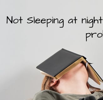 Woman with book over her head sleeping at her desk