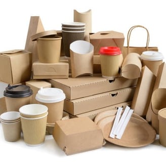 a pile of cardboard boxes with coffee cups and packaging board