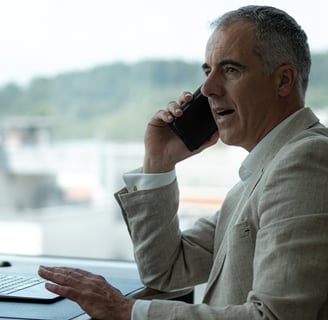 a man sitting at a table with a laptop and a laptop