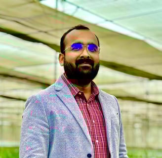 a man in a suit and sunglasses standing in a greenhouse