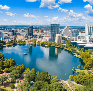 a city skyline view of a lake and a boat in the water in orlando