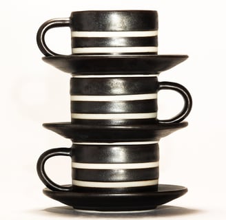 a stack of three cups with a cup of coffee