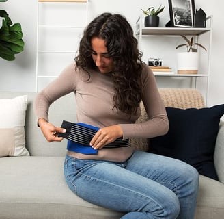 a woman sitting on a couch with a hair brush