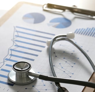 A stethoscope on top of a report with graphs on a clipboard