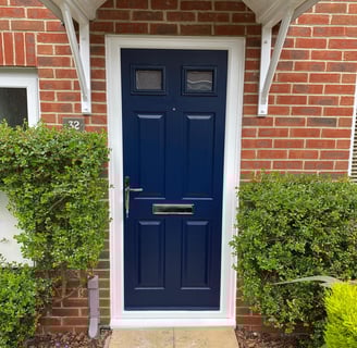 blue front door on red brick house with 2 panels of glass